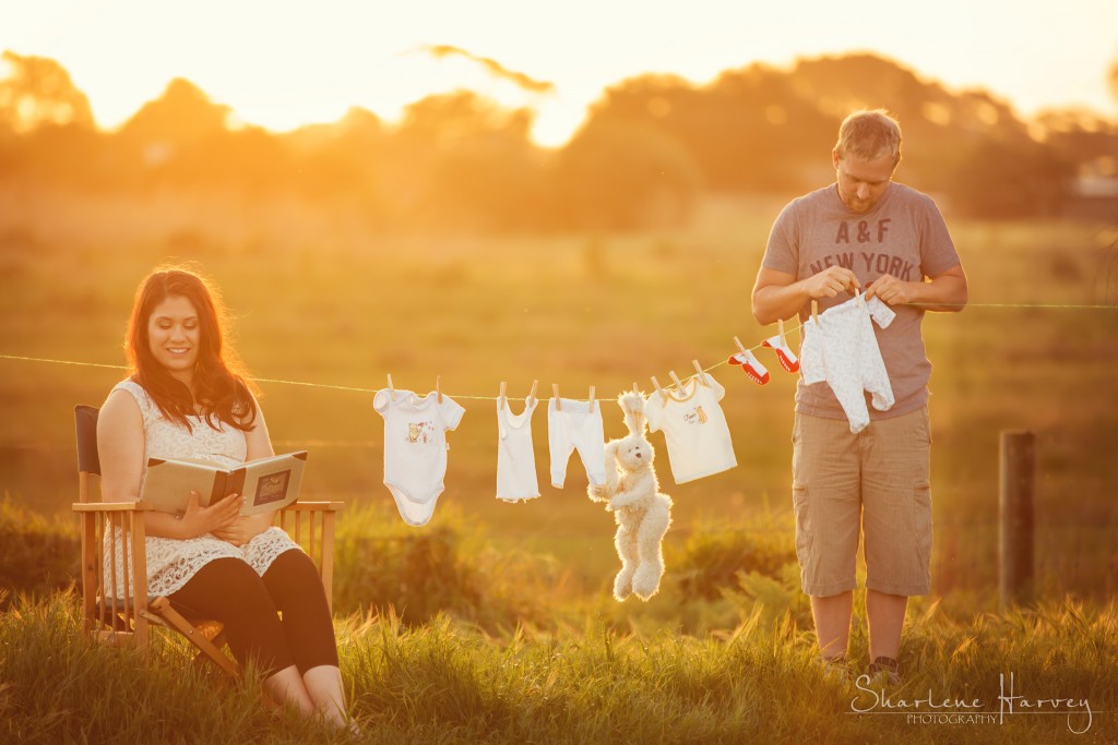 Pregnant mother sets up a clothes line with cute baby clothes and sets dad to work