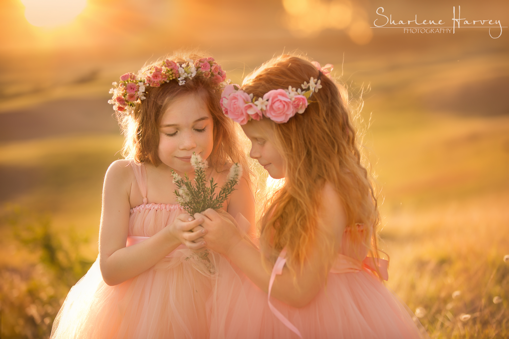 Gorgeous Girls in sunlight smelling flowers